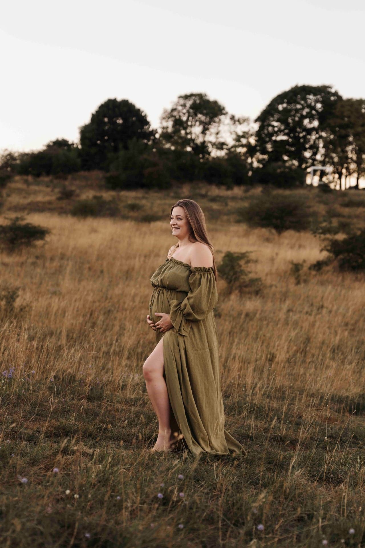 Babybauch Outdoor Shooting Niederösterreich – Lucia im olivgrünen Kleid, Wind im Stoff
