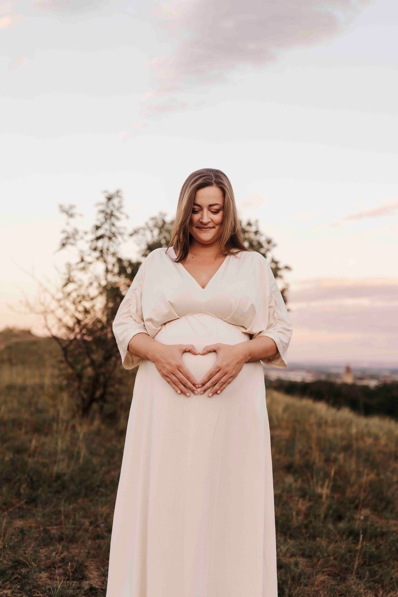 Babybauch Shooting Sonnenuntergang Wien – Herz aus Händen auf dem Bauch