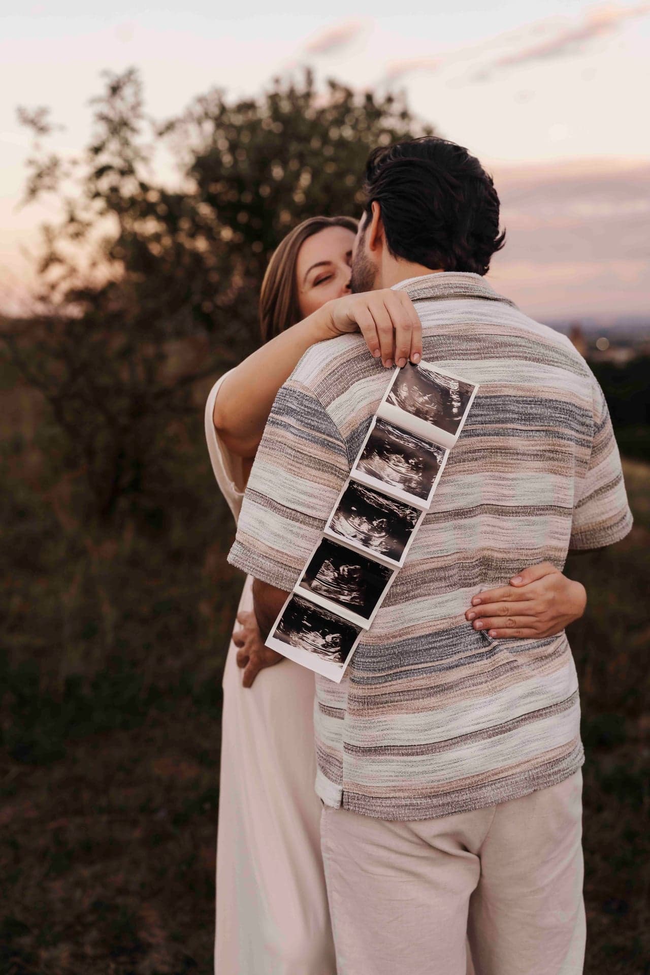 Babybauch Shooting mit Ultraschallbild – Umarmung mit dem Ultraschallbild in der Hand, Outdoor Wien