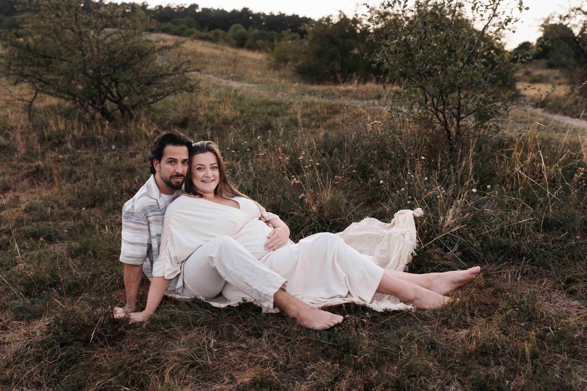 Babybauch Paarshooting auf der Wiese – Lucia & Max liegen entspannt im Gras, Niederösterreich